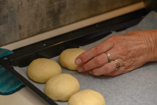 woman placing buns on a baking sheet 2