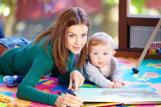 Portrait, woman and baby with book in home for learning, development or cognitive growth for education. Mother, son or family with reading, bond and lying on floor in living room with toys for future.