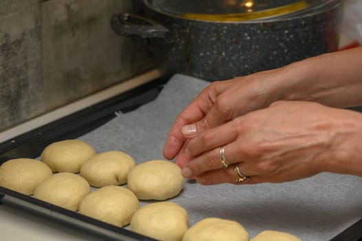 woman placing buns on a baking sheet 8