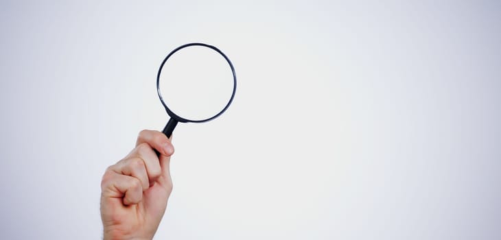 Magnifying glass searching for deals, hand and investigation, search or study with mockup space on white background. Knowledge, source and spy person with analysis, research and reading with problem .