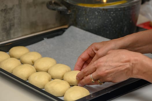 woman placing buns on a baking sheet 10