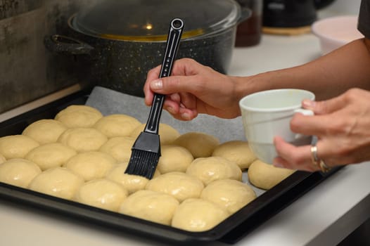 woman greases buns in the kitchen 3