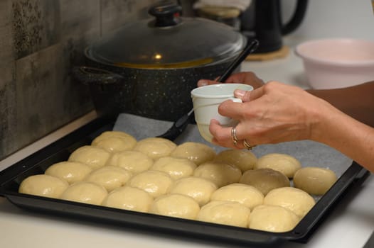 woman greases buns in the kitchen 1