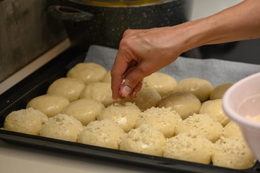 woman sprinkles buns in the kitchen 1