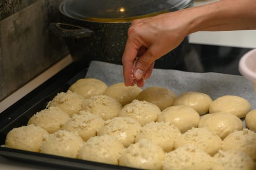 woman sprinkles buns in the kitchen 2