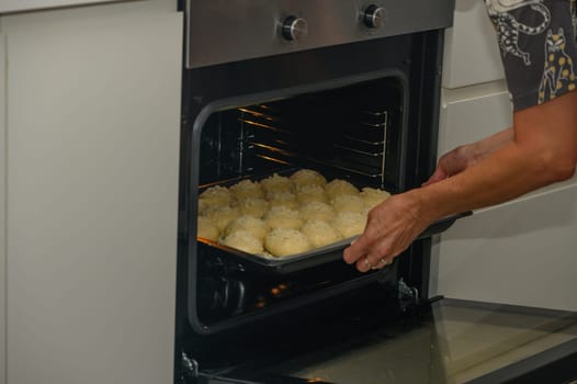 woman puts buns in the oven on a baking sheet 3