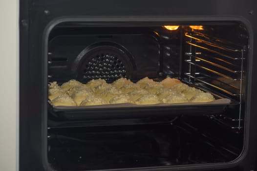 woman puts buns in the oven on a baking sheet 4