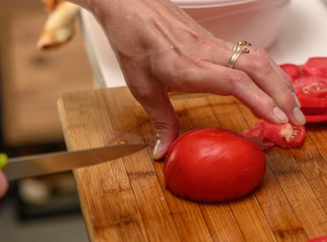 woman cutting tomato on kitchen board 5