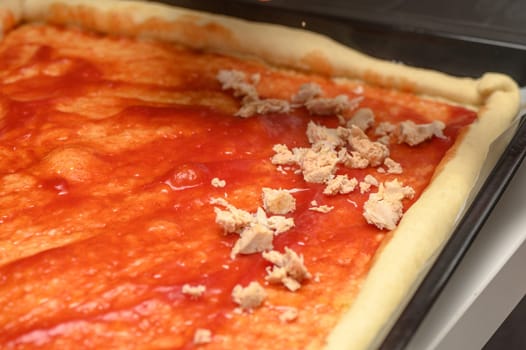 woman putting meat on pizza in the kitchen 1