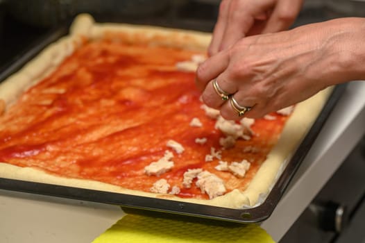 woman putting meat on pizza in the kitchen 2