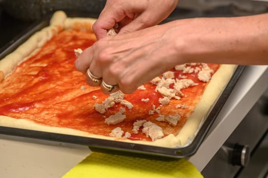 woman putting meat on pizza in the kitchen 3