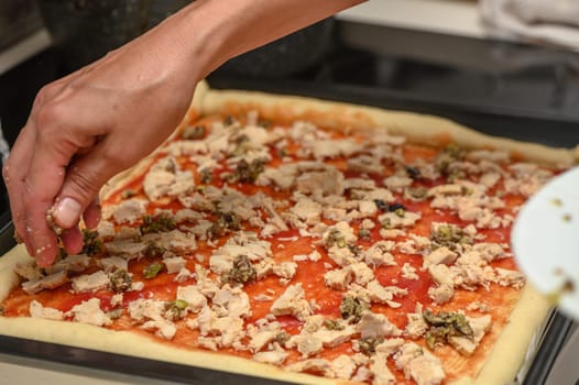 a woman prepares pizza with cheese, tomatoes and chicken ham, a woman lays out chicken ham 4