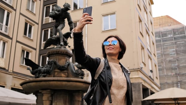 Stylish Woman Strolls Through Historical Touristic Streets In Dresden, Capturing Images Of Monument