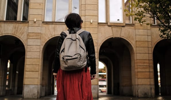 Attractive Woman Walks In City With Backpack, Looking Around