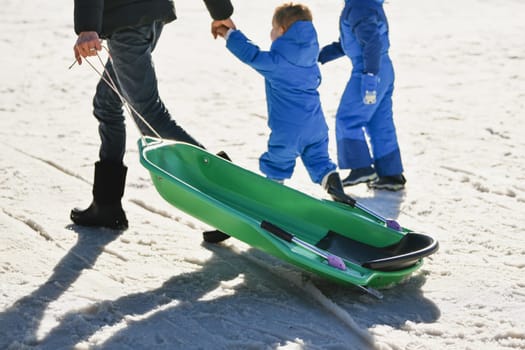 The father with children sledding in the snow