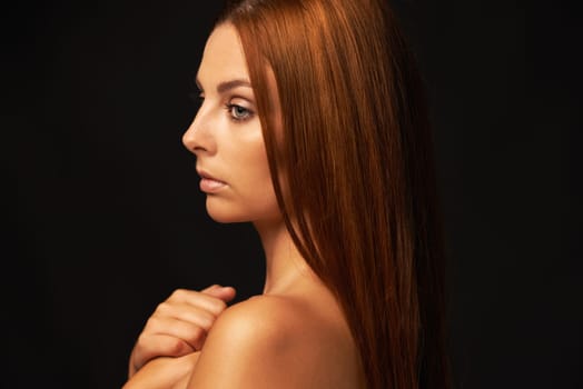 Hair care, ginger or woman thinking of beauty, skincare or results for glow, shine or collagen in studio. Black background, growth or serious model with cosmetics for healthy texture or textures.
