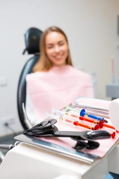 Close up tools for teeth whitening with happy patient on the background in dentist office.