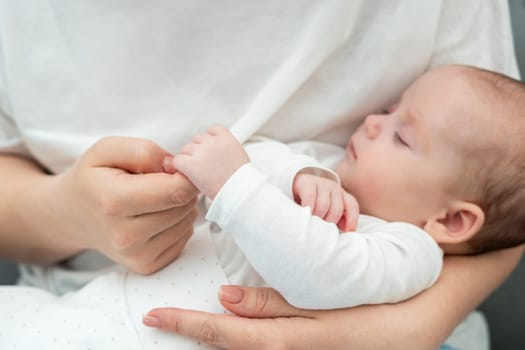 Newborn infant, in a delicate moment, tenderly holds mother's finger emphasizing a deep, unspoken connection