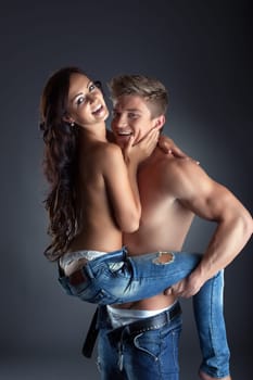 Image of happy topless lovers posing in trendy jeans