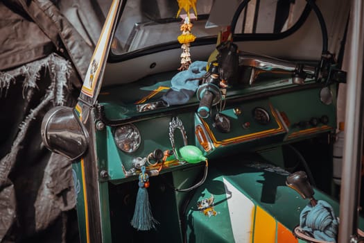 Bangkok, Thailand - Apr 06, 2022 : Dashboard and steering wheel and shift lever inside Thai traditional taxi or Three wheels vehicle  (3-wheeler taxi). Tuk-Tuk car interior design. Selective focus.
