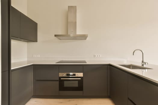 a modern kitchen with white counter tops and black cabinetry, which is also used as an accent to the space