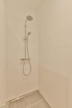 a shower with white tiles on the walls and tile floor in a bathroom area that is clean and ready for use