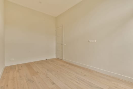 an empty room with white walls and wood flooring on the right, there is a door in the corner