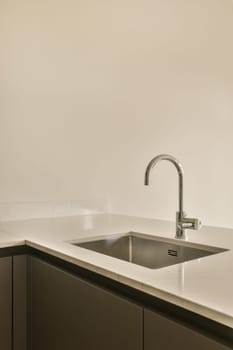a kitchen sink and counter in a room that is white with black trim on the walls, there is an empty wall behind it