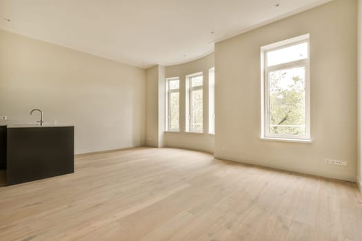 an empty living room with wood flooring and large windows looking out onto the trees in the distance from the window
