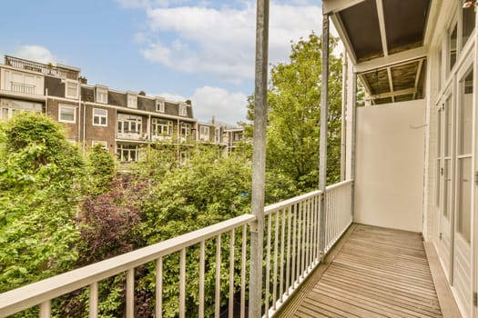 a balcony with trees and houses in the background on a sunny day, taken from an apartment window looking out onto the street