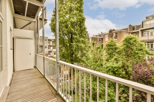 a balcony with trees and buildings in the background, taken from an apartment window looking out onto one of the street