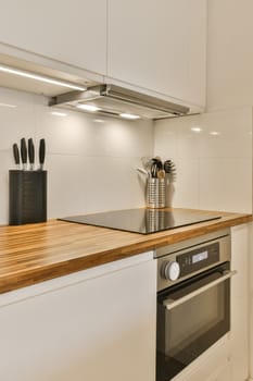 a kitchen with white cabinets and wood counter tops in the center of the image is an oven, dishwasher, and ut