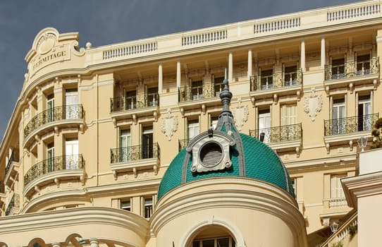 Monaco, Monte Carlo, 27 September 2022: The facade of famous Hotel Hermitage at sunny day, building of yellow color, balcony, bas-relief. High quality photo