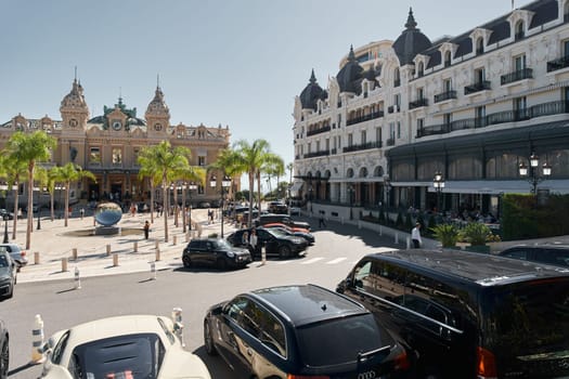 Monaco, Monte-Carlo, 21 October 2022: Square Casino Monte-Carlo at sunny day, a lot of luxury cars, Hotel de Paris, wealth life, tourists take pictures of the landmark, pine trees, blue sky, flowers. High quality 4k footage