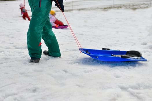 The children sledding in the snow