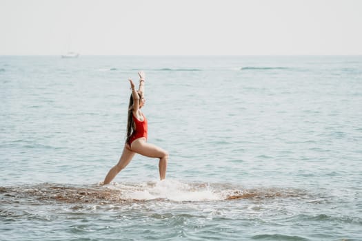 Woman sea yoga. Back view of free calm happy satisfied woman with long hair standing on top rock with yoga position against of sky by the sea. Healthy lifestyle outdoors in nature, fitness concept.