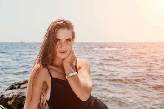 Woman travel sea. Young Happy woman in a long red dress posing on a beach near the sea on background of volcanic rocks, like in Iceland, sharing travel adventure journey