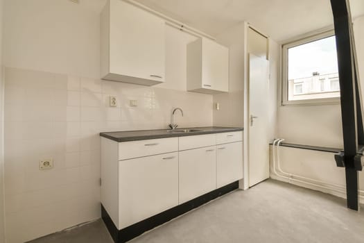 a kitchen area with white cabinets and black counter tops on the floor in front of the door to the room