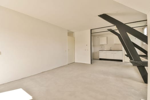 an empty living room with stairs leading up to the second floor and kitchen in the wall is white, but there's no