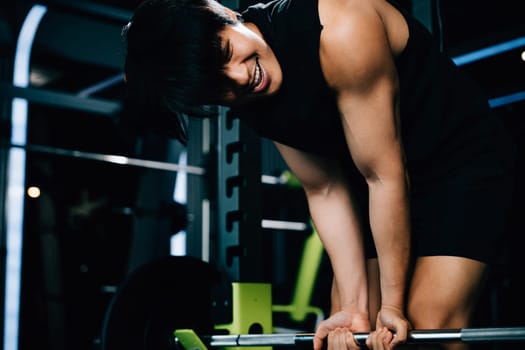 A powerful athlete lifting weights and holding a barbell for a functional training and strength-building workout in the gym. power lifting training concept