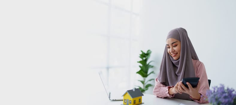 muslim woman with hijab using calculator focus on utility bills calculate check credit card receipt monthly expense