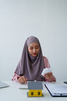 muslim woman with hijab using calculator focus on utility bills calculate check credit card receipt monthly expense