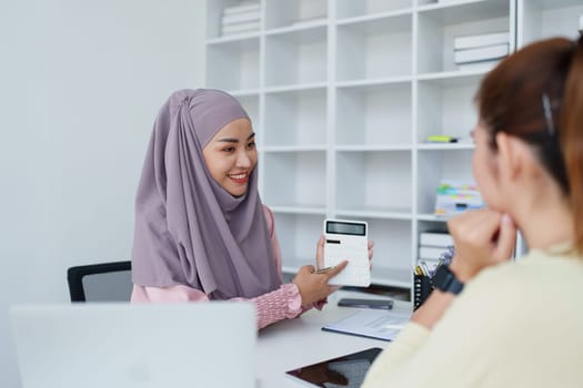 A female Muslim bank employee, making an agreement on a residential loan with a customer