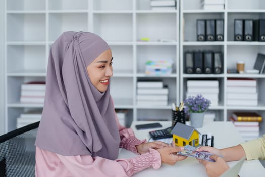 A female Muslim bank employee, making an agreement on a residential loan with a customer