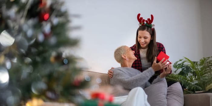 Caucasian Family, winter holiday and concept happy mother and daughter decorating christmas tree and give a gift at home.