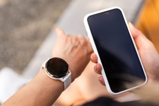 phone in the hands of a girl and a smart watch on her hand mockup. High quality photo
