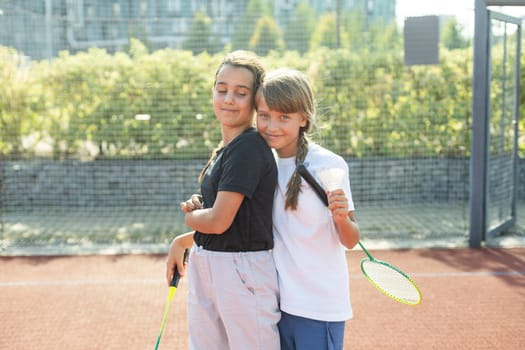 Two girls with badminton rackets on the football field. High quality photo