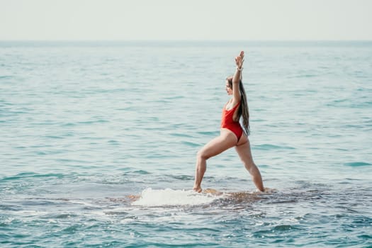 Woman sea yoga. Back view of free calm happy satisfied woman with long hair standing on top rock with yoga position against of sky by the sea. Healthy lifestyle outdoors in nature, fitness concept.