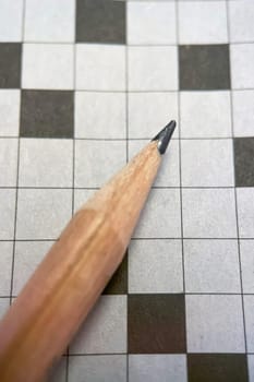 crossword puzzle and pencil on it. close up macro photo.