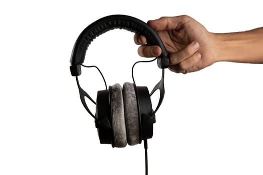 Black male hand holding studio headphones isolated